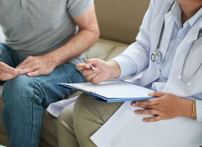 unrecognizable-female-doctor-sitting-on-couch-with-male-patient-and-filling-form 1.jpg